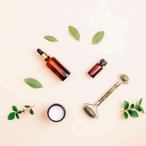 Modern apothecary, natural ingredients. Cosmetic serum, cream, facial roller and essential oil.
